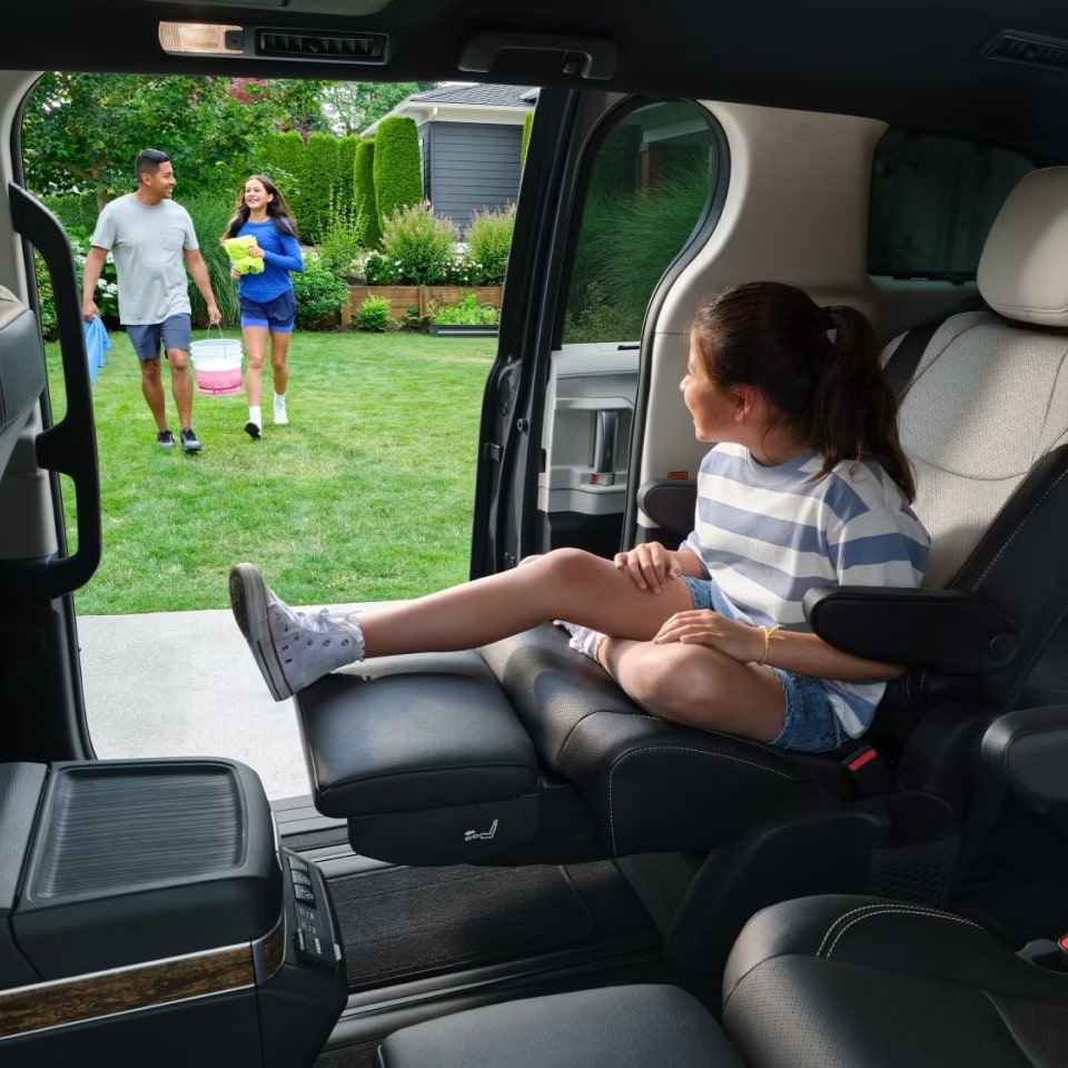 young girl sitting in the back seat of a Toyota Sienna